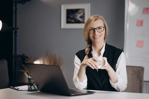 Business lady drinking coffee while working on laptop Stock Photos