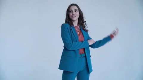 A business lady poses in a blue jacket and trousers on a white background. The Stock Footage 137084565
