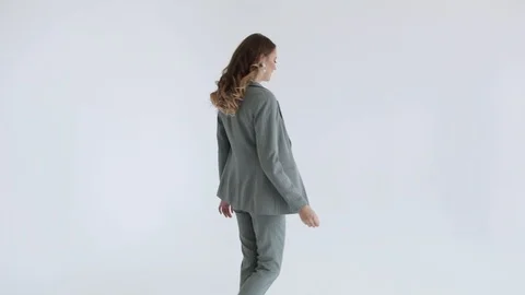 Business lady posing in a gray jacket and trousers on a white background. Stock Footage 106281840