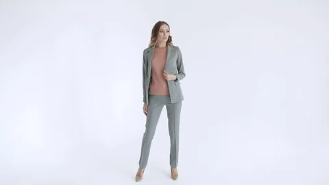 Business lady posing in a gray jacket and trousers on a white background. Sexy Stock Footage 106282079