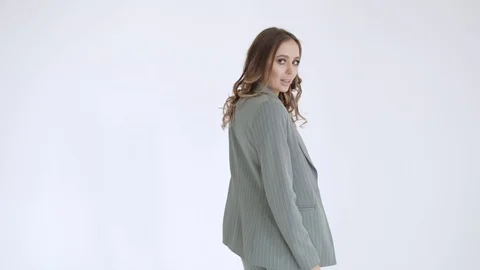Business lady posing in a gray jacket and trousers on a white background. Sexy Stock Footage 106282263