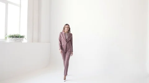 Business lady posing in a jacket and trousers on a white background.  库存影片 105008258