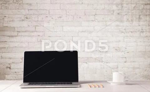 Business laptop with white brick wall Stock Photos