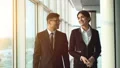 The business man and a woman discuss near windows in the office. slow motion HD Footage