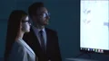 The business man and a woman discussing near the display 4k or 4k+ Resolution