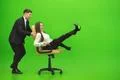 The business man and the woman fun on the chair on the green background Photo