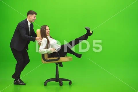 The business man and the woman fun on the chair on the green background Stock Photos