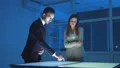 The business man and a woman working with virtual screen in the dark room 4k or 4k+ Resolution