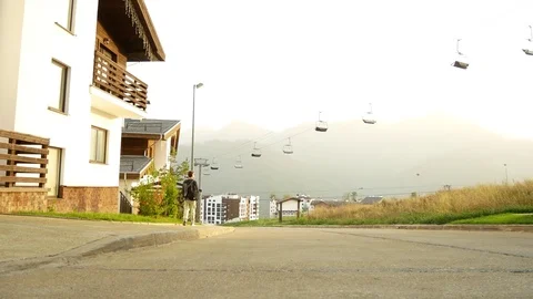 Business man on a background of a chalet, a house in the mountains. 4k. enjoys Stock Footage 80320260