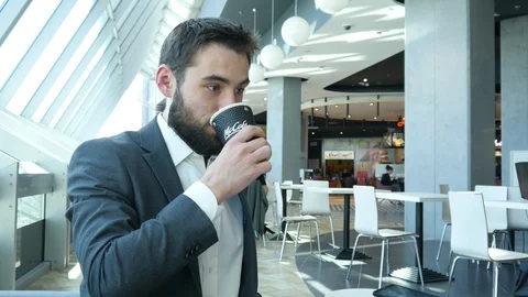 Business Man with Beard on a Face drinks McDonald's Coffee in Office Stock Footage 106788339