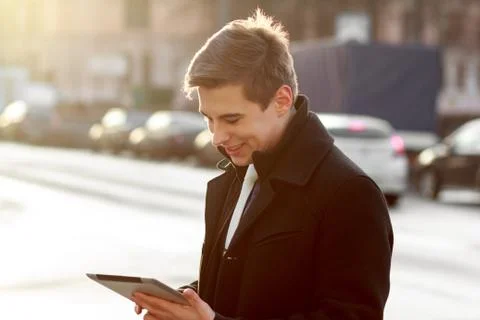Business man in coat using tablet Stock Photos