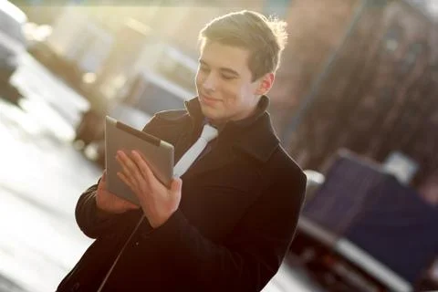 Business man in coat using tablet Stock Photos