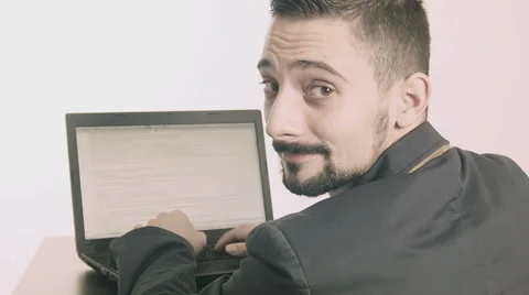 Business man computer programmer typing at his desk and looking at camera Stock Footage 45885485