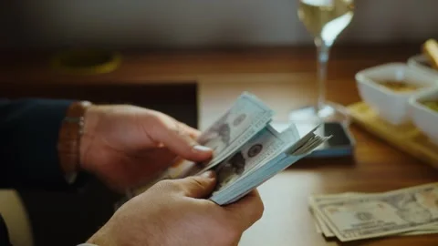 Business man counting stack of hundred dollar bills inside private jet whil.. Stock Footage 337546761