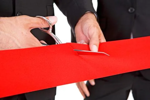 Business: Man Cuts Through Red Ribbon with Scissors Stock Photos