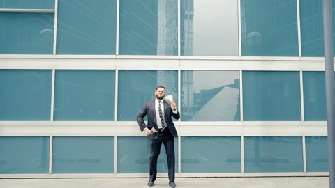 Business man dancing and throwing a wad of cash on the street Stock Footage 112916675