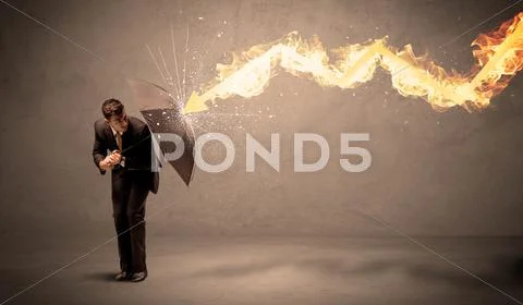 Business man defending himself from a fire arrow with an umbrella Stock Photos