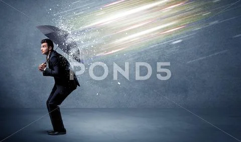 Business man defending light beams with umbrella concept Stock Photos