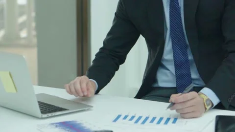 A business man documents on office table with laptop and graph business. Video stock 242096593