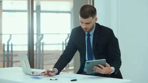 A business man documents on office table with laptop and graph business. Video stock 242096595