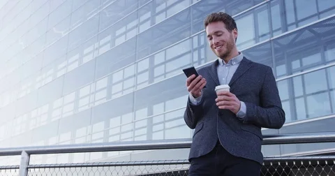 Business man drinking coffee using mobile cell phone app Stock Footage 75057067