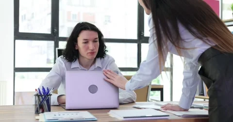 Business man explaining work to female colleague using laptop computer in office Stock Footage 249651719