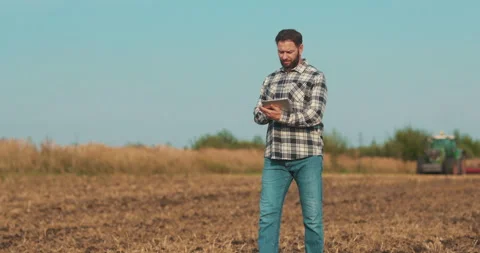 Business man farmer working with tablet computer walking on the field. Stock Footage 263950752