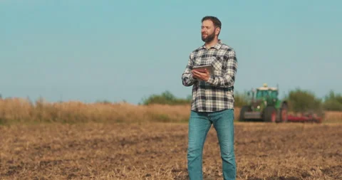 Business man farmer working with tablet computer walking on the field. Stock Footage 263950797