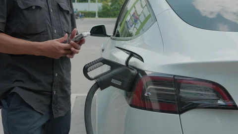 Business man hand use electonic car charge batterry in EV station Stock Footage 255208280