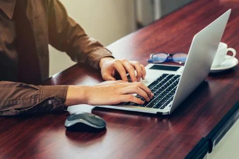 Business man hand using computer laptop in the office with sunlight. Vintag.. Foto stock