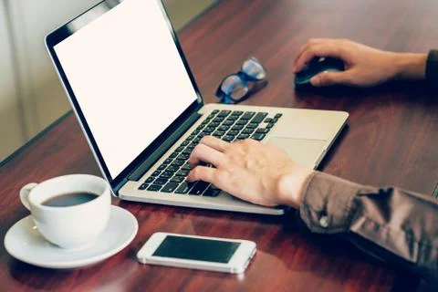 Business man hand using computer laptop in the office with sunlight. Vintag.. Stock Photos