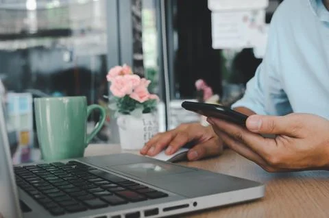 Business man hand using mobile smart phone and mouse computer laptop on tab.. Stock Photos