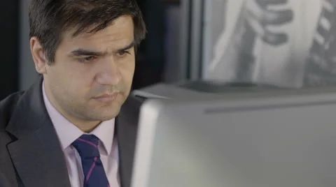 Business man at his computer looking confused Stock Footage