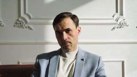 Business man in a jacket with a turtleneck strictly looks at the camera Video stock 152038688