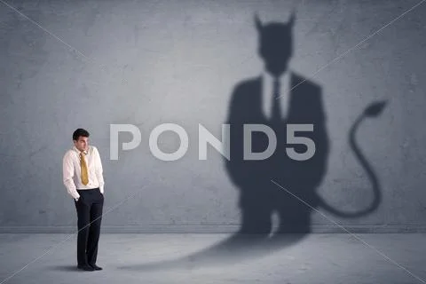 Business man looking at his own devil demon shadow concept Stock Photos