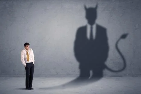 Business man looking at his own devil demon shadow concept Stock Photos