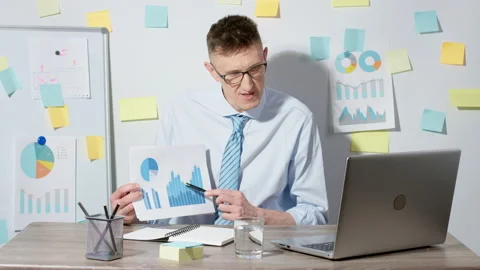 Business man looking at the statistical and graphical data Stock Footage 229974250