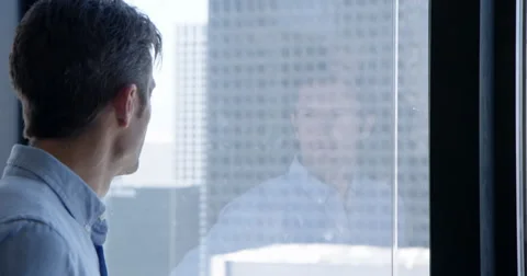 Business man looks through windows and sees reflection in Downtown LA 4K Stock Footage 67390647