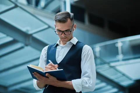 Business man making notes in a notebook . Stock Photos