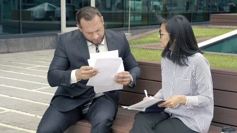 Business man manager submitting papers for signature to his strict boss woman Stock Footage 110748490