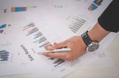 Business man marking on data sheet using metal pen Stock Photos