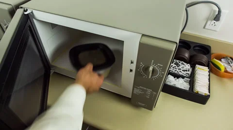 Business man opening microwave to remove left overs Stock Footage 32243222