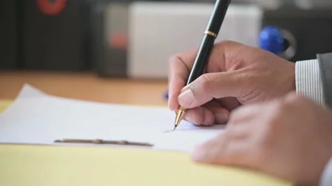 A business man with a pen signing a document to approve financial and account Stock Footage 132085694
