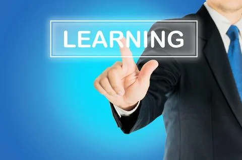 Business man is pushing LEARNING transparent button word over blue gradient.. Stock Photos