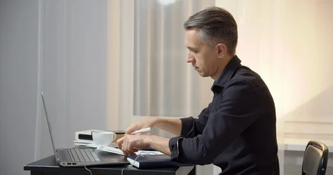 Business man reading documents and typing text or message on laptop at workplace Stock Footage 127029209
