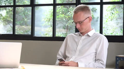 Business man relaxing using smartphone in office Stock Footage 248886947