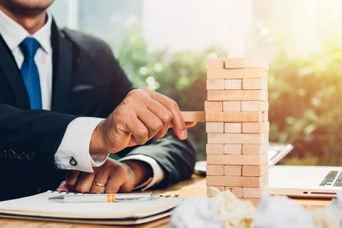Business man risk game pull block wood on desk office Stock Photos