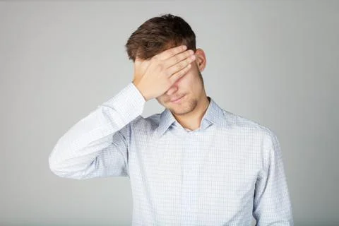 Business man in shirt holds his forehead with hand. He looks exhausted. Stock Photos