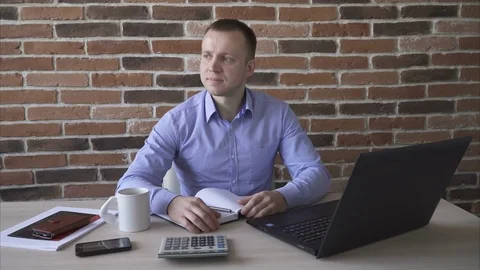 Business man sitting at the table and looking to the camera Stock Footage 73396552