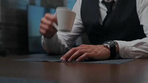 Business man sitting at the table in the office, drinks coffee from a white cup Stock Footage 201199907